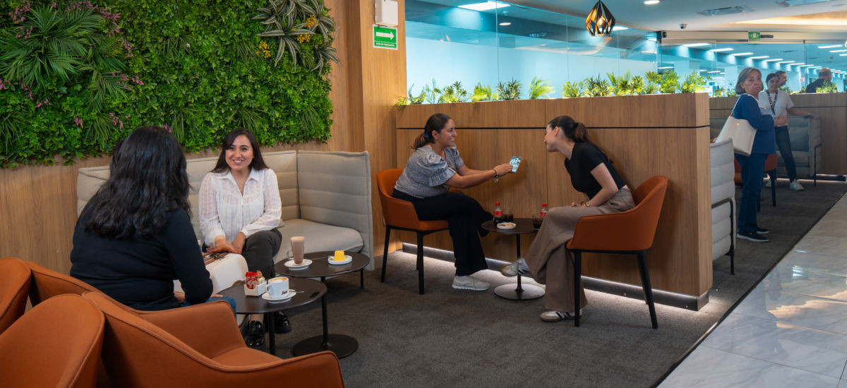 Vista general del salón con áreas de descanso y mesas altas